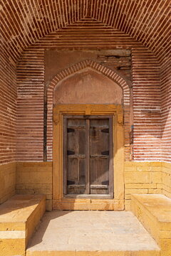 View of the historic wooden door and intricate brickwork archway at the Makli Necropolis in Thatta, Sindh, Pakistan.