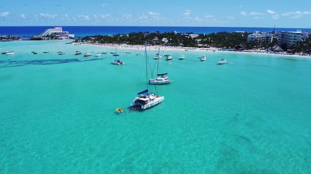 Aerial view of catamarans and boats anchored in the turquoise waters off the coast of Isla Mujeres, Quintana Roo, Mexico.