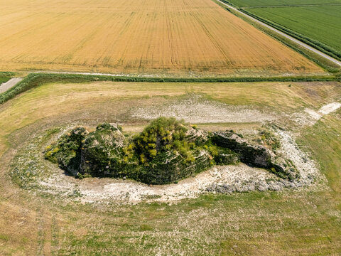Aerial view of the Dijk van een wijf earthwork sculpture surrounded by agricultural fields in Oosterbierum, Friesland, Netherlands.