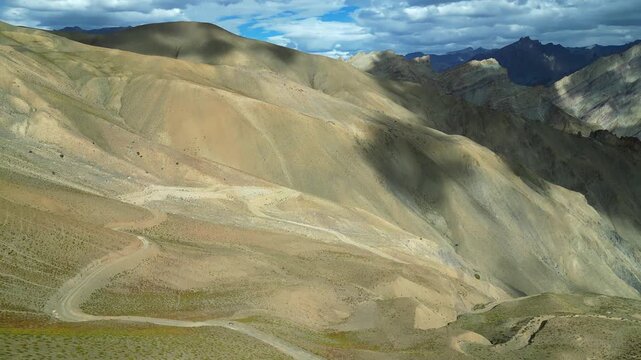 Aerial view of the rugged Zanskar valley landscape with sparse vegetation and rocky terrain in Zanskar, Ladakh, India.
