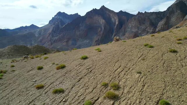 Aerial view of the rugged Zanskar valley landscape featuring winding dirt roads and towering mountain peaks in Zanskar, Ladakh, India.