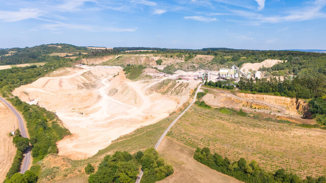 Aerial view of a limestone quarrying operation with extraction pits, processing facilities, and surrounding rural landscape in Trier-Saarburg, Rhineland-Palatinate, Germany.