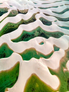Aerial view of Lagoa Bonita featuring white sand dunes and vibrant green lagoons in the Lencois Maranhenses National Park in Barreirinhas, State of Maranhao, Brazil.