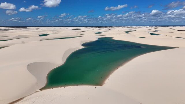 Aerial view of white sand dunes and turquoise lagoons in Parque Nacional dos Lencois Maranhenses, MA, Brazil.