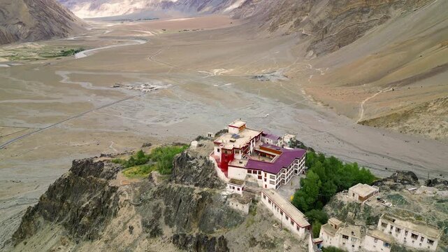 Aerial view of the historic Zanskar monastery perched on a rocky cliff overlooking the vast arid valley in Zanskar, Ladakh, India.