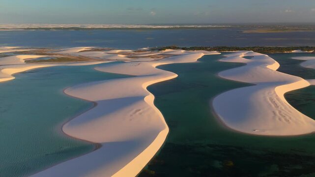 Aerial view of white sand dunes and turquoise lagoons in Parque Nacional dos Lencois Maranhenses, MA, Brazil.