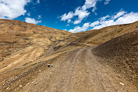 Scene featuring dirt road in mountains (Himalayas). Spiti Valley, Himachal Pradesh, India