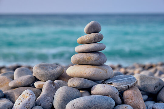 A zen meditation relaxation concept background - balanced stones stack close up on sea beach