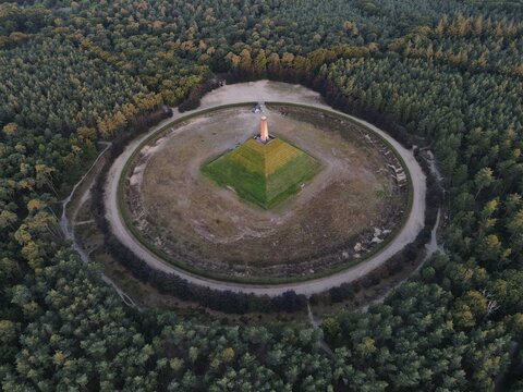 Netherlands - 12 July 2026: Aerial view of the Pyramid of Austerlitz, a historic monument surrounded by dense forest, featuring a central obelisk atop a grass-covered pyramid structure.