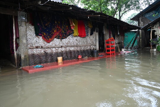 Banshkhali Upazila, Bangladesh - 11 July 2026: View of a flooded residential area with a traditional bamboo-walled house partially submerged in muddy water during monsoon season.
