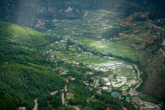 Aerial view of Paro Valley View Point featuring lush green rice terraces, winding roads, and forested mountain slopes in Paro, Paro, Bhutan.