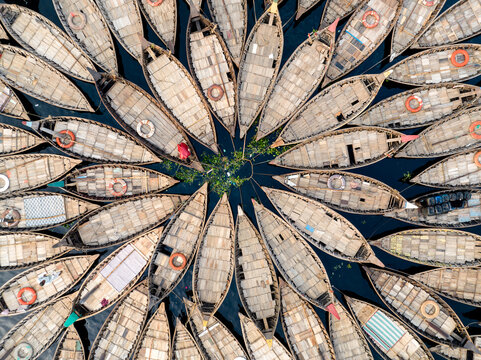 Aerial view of wooden boats arranged in a circular pattern on the Buriganga River in Dhaka Division, Bangladesh.