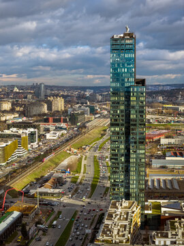 Aerial view of Kula Belgrade skyscraper rising above the urban landscape with busy roads, railway tracks, and city buildings in Belgrade, City of Belgrade, Serbia.