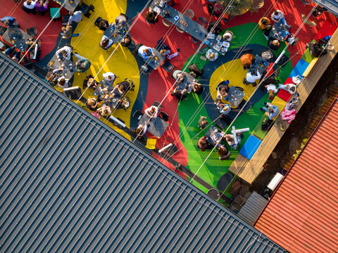 Aerial view of an outdoor seating area with colorful painted floor patterns, tables, and people dining in Belgrade, City of Belgrade, Serbia.