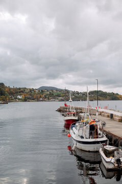 Boats docked in a Norwegian harbor on a cloudy autumn day