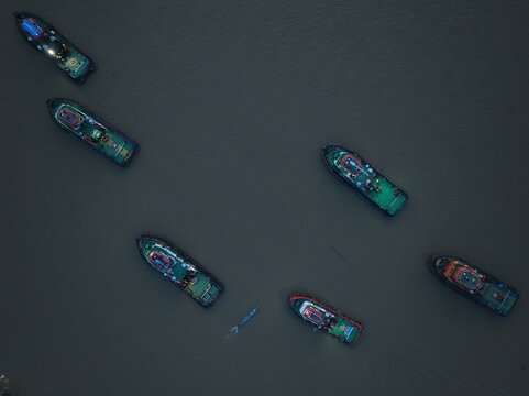 Aerial view of several tugboats navigating the river waters in Berau Regency, East Kalimantan, Indonesia.