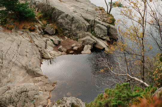 Rocky Norwegian coastline with calm water and autumn foliage