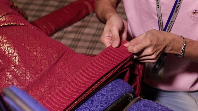 Thai classical Khon performer getting dressed and adjusted in traditional ornate costume before performance In Bangkok.