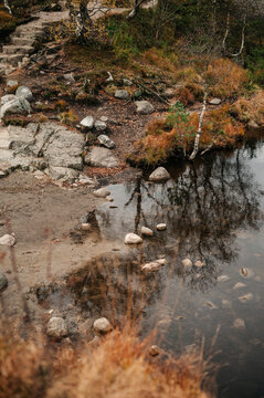 Autumnal Norwegian landscape with rocky shore and reflective water