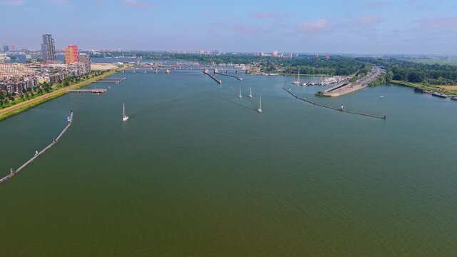Aerial view of the IJ waterway with sailboats and modern architecture in Amsterdam, North Holland, Netherlands.