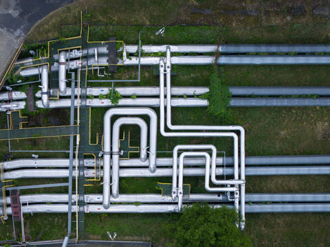 Aerial view of industrial pipes arranged in a complex network over green grass in Krakow, Lesser Poland Voivode, Poland.