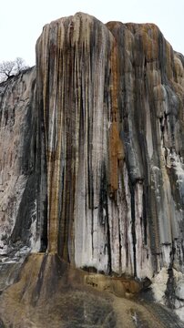 Aerial view of Hierve el Agua, a natural rock formation resembling a cascading waterfall with mineral deposits and layered stone textures in Oaxaca de Juarez, Oaxaca, Mexico.