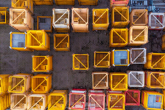 Aerial view of yellow crane mast sections arranged in rows on a paved surface in Pruszkow, Wojewodztwo mazowieckie, Poland.