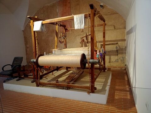 Tlemcen, Algeria - July 27, 2024: Traditional wooden handloom exhibit at the El Mechouar Palace museum highlighting historic Algerian textile craft