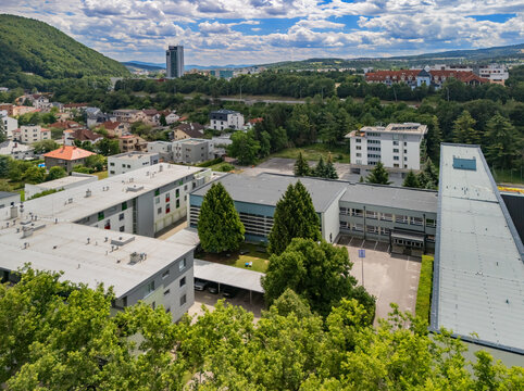 Aerial view of the Secondary Technical School of Jozef Murgas with modern school buildings, surrounding green trees, and parking areas in Banska Bystrica, Banskobystricky kraj, Slovakia.