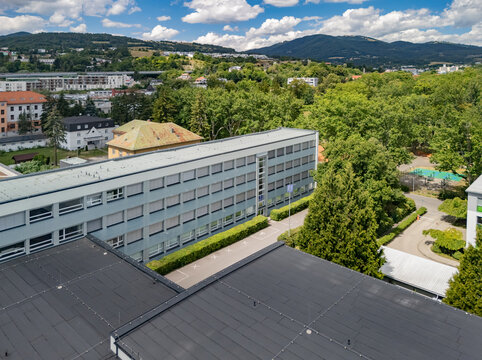 Aerial view of the Secondary Technical School of Jozef Murgas surrounded by lush green trees and parkland with hills in the background, Banska Bystrica, Banskobystricky kraj, Slovakia.
