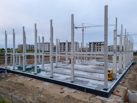 Aerial view of a construction site featuring concrete pillars and beams with a tower crane in the background in Gdansk, Pomeranian Voivodeship, Poland.