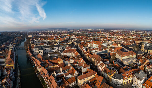 Aerial view of the historic city of Bamberg with its dense red-tiled rooftops and the Regnitz river flowing through the urban landscape in Bamberg, Bavaria, Germany.