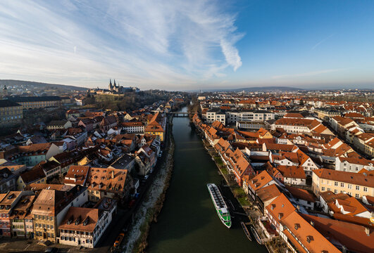 Aerial view of the historic city of Bamberg with its iconic red-tiled rooftops, the winding Regnitz river, and the cathedral in the distance, Bamberg, Bavaria, Germany.
