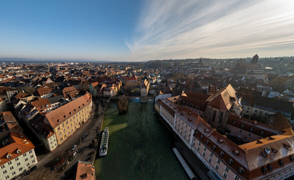 Aerial view of the historic Old Town of Bamberg with the Regnitz river, the iconic Old Town Hall, and traditional red-tiled rooftops in Bamberg, Bavaria, Germany.