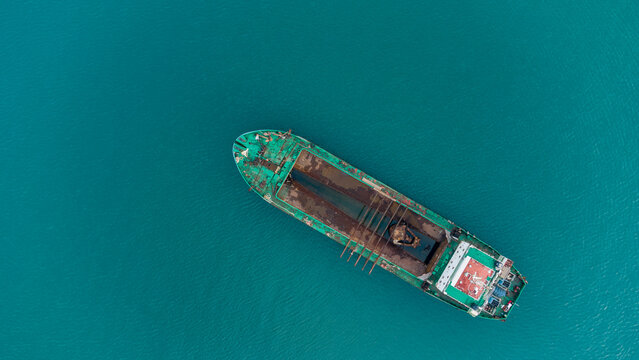Aerial view of a cargo ship navigating through the turquoise waters near the port in Accra, Greater Accra, Ghana.
