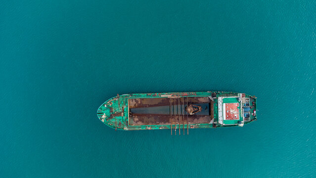 Aerial view of a cargo ship docked at MPS Terminal 3 in the port of Accra, showing the vessel's deck against the turquoise water of the Atlantic Ocean in Accra, Greater Accra, Ghana.