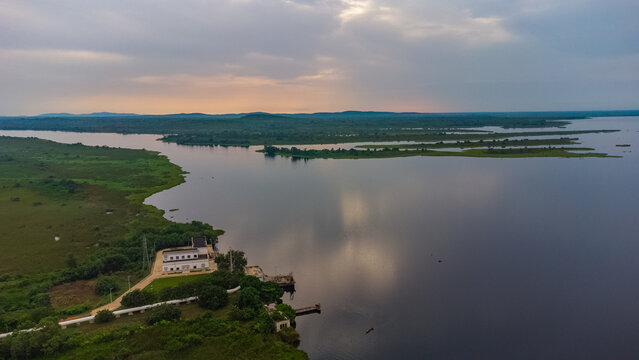 Aerial view of the GWCL - Old Works Plant situated along the Volta River, featuring industrial buildings, lush green vegetation, and calm water in Kpong, Eastern Region, Ghana.