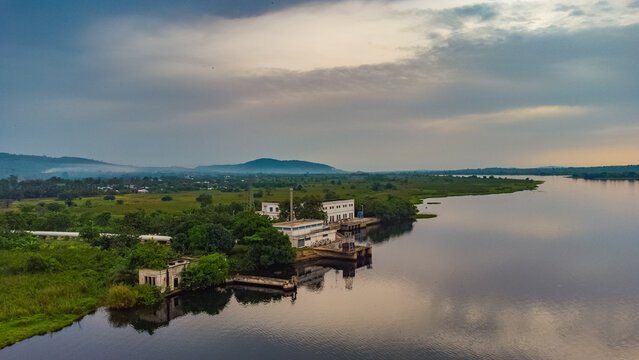 Aerial view of GWCL - Old Works Plant situated along the Volta River with lush green surroundings and calm water in Kpong, Eastern Region, Ghana.