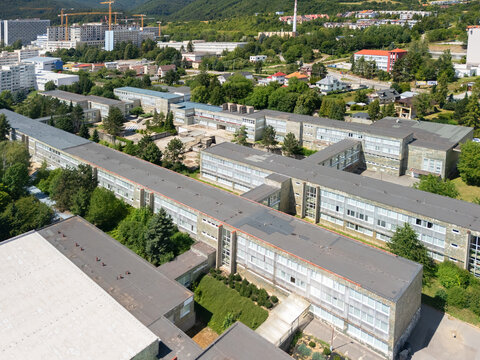 Aerial view of Marek Frauwirth Business Academy and Gymnazium Jozefa Gregora Tajovskeho, featuring school buildings and green trees in Banska Bystrica, Banskobystricky kraj, Slovakia.