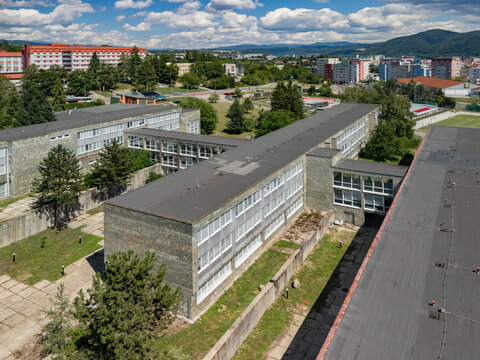 Aerial view of Marek Frauwirth Business Academy and Gymnazium Jozefa Gregora Tajovskeho, featuring school buildings with flat roofs in Banska Bystrica, Banskobystricky kraj, Slovakia.