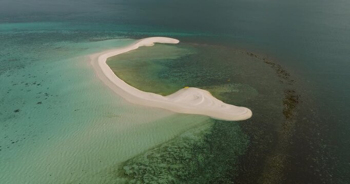 Aerial view of White Island sandbar surrounded by turquoise and deep blue waters in Mambajao, Camiguin, Philippines.