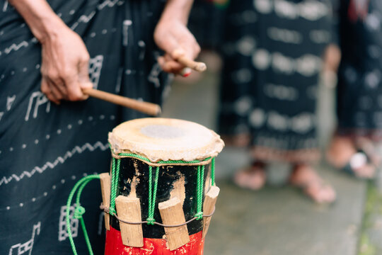 Bajawa, Nusa Tenggara Timur, Indonesia - 09 July 2026: View of a person playing a traditional drum with patterned ikat fabric.