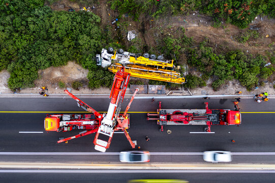 Aerial view of an overturned truck on the side of the road with emergency response vehicles and cranes working on the scene in Rosh Haayin, Center District, Israel.