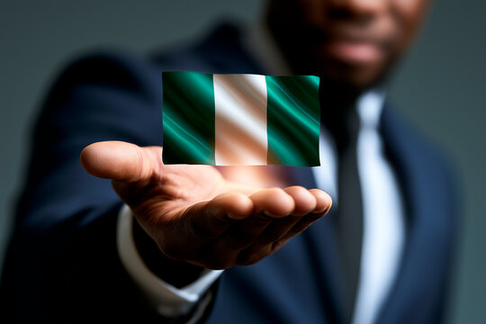 Businessman holding glowing digital Nigeria flag hologram over extended hand