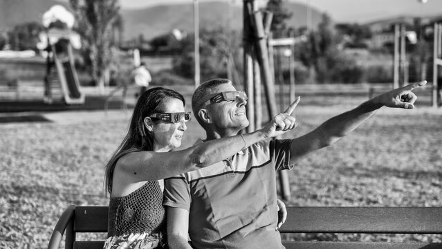 Dramatic black and white scene of family observing solar eclipse outdoors