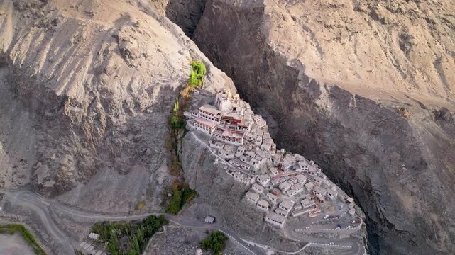 Aerial view of Diskit Monastery nestled in a rocky mountain gorge with traditional buildings and surrounding arid landscape in Diskit, Ladakh, INDIA.