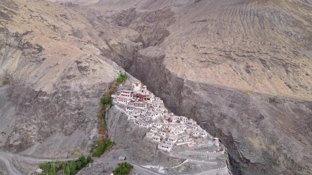 Aerial view of Diskit Monastery perched on a rocky cliffside with traditional white buildings and winding roads in Diskit, Ladakh, India.