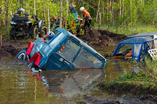 View of off-road vehicles stuck in deep mud and water during an off-road competition near Lake Ladoga in the forest, Sortavala, Respublika Kareliya, Russia.