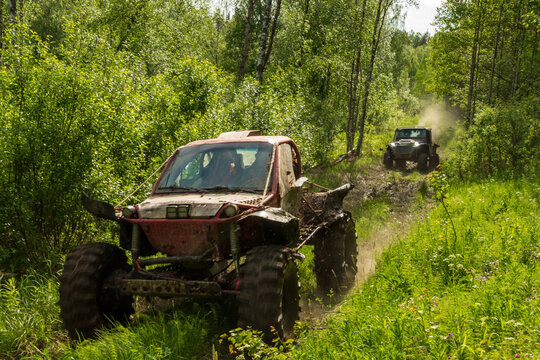 View of two off-road buggies driving along a muddy forest trail near Lake Ladoga in Sortavala, Respublika Kareliya, Russia.