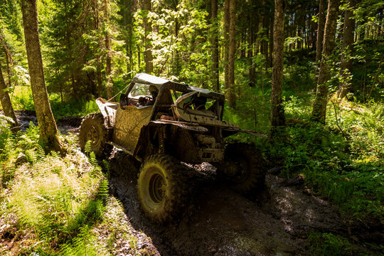 View of an off-road vehicle driving through a muddy forest path near Lake Ladoga in Sortavala, Respublika Kareliya, Russia.